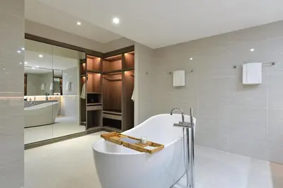 a bathroom with a bath tub and a shower at GM Estate Hotel and Executive Apartments, Bangkok Sukhumvit 20 in Bangkok