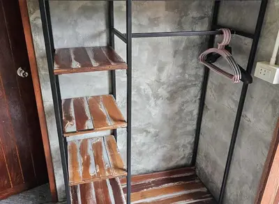 two rusty metal shelves in a room with a wall at Nipatra Homestay in Ban Khlong Bang Sai
