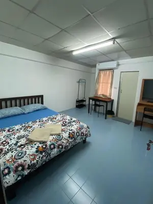 a bedroom with a bed and a table in it at รัตนากร แมนชั่น in Bang Su