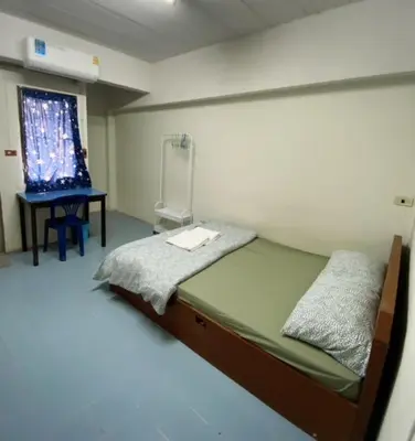 a room with a bed and a desk and a window at รัตนากร แมนชั่น in Bang Su