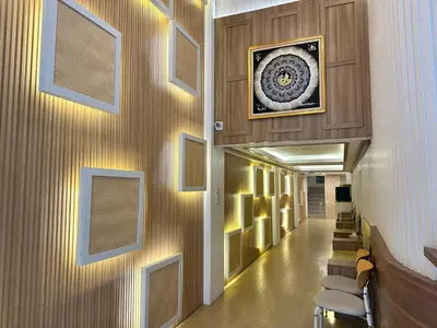 a hallway in a hospital with a painting on the wall at Winston Hotel in Bangkok