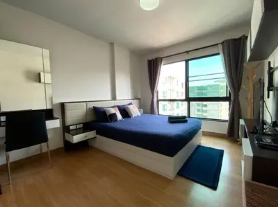a bedroom with a blue bed and a large window at Home at Sena in Bangkok