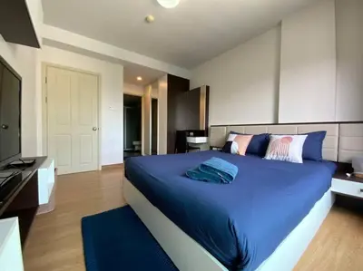 a bedroom with a large bed with blue sheets at Home at Sena in Bangkok