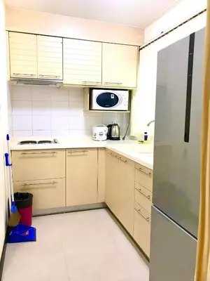a kitchen with white cabinets and a stainless steel refrigerator at Charming Resident Sukhumvit 22 in Bangkok