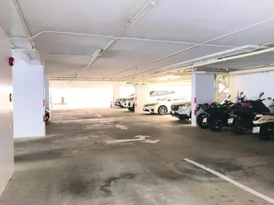 an empty parking lot with parked motorcycles and cars at Charming Resident Sukhumvit 22 in Bangkok