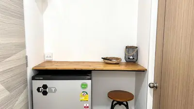 a small kitchen with a counter on top of a refrigerator at 65 Hostel Bangkok in Bangkok Noi