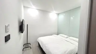 a white room with a bed and a mirror at 65 Hostel Bangkok in Bangkok Noi