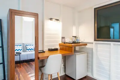 a room with a desk and a mirror and a chair at Resort Bangphlat in Bang O