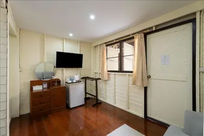 a room with a television and a small refrigerator at Resort Bangphlat in Bang O