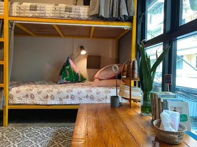 a bedroom with two bunk beds and a wooden table at The Space Hometel - Women Only in Pom Prap