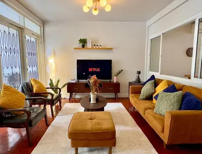 a living room with a couch and a tv at Flow In House in Bangkok