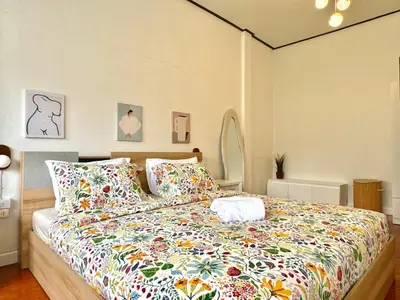 a bedroom with a large bed with colorful pillows at Flow In House in Bangkok