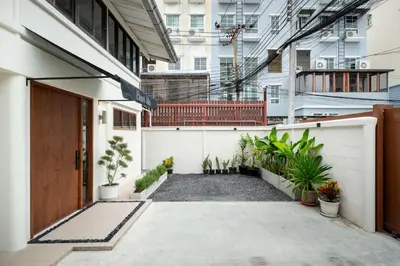 a courtyard of a building with potted plants at Baan Jila in Bangkok