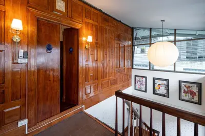 a hallway with wood paneled walls and a staircase at Baan Jila in Bangkok