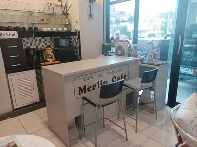 a kitchen with a counter with stools and a kitchen cart at Merlin MANSION 107 in Ban Khlong Samrong