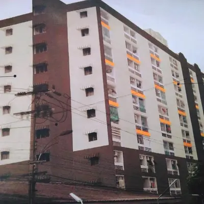 a tall white and red building with windows at Merlin MANSION 107 in Ban Khlong Samrong