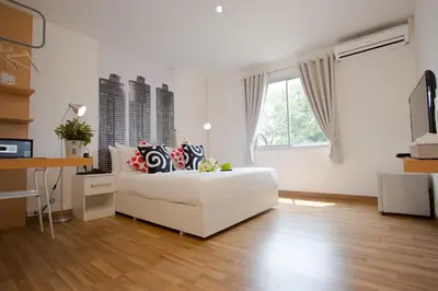 a white living room with a bed and a desk at Anda Ramkhamhaeng By St James Hotel in Bangkok