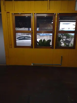 a yellow wall with three windows and a white car at 362 สวนอ้อย5 in Dusit