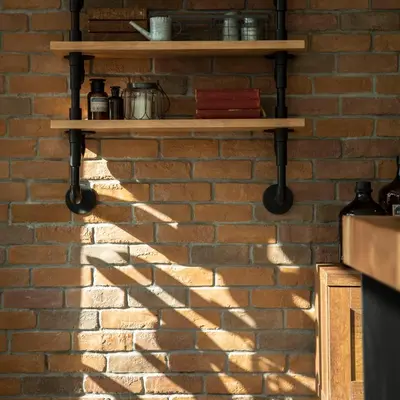 a shadow of a brick wall with wooden shelves at Parrish Serviced Apartment in Bang Mote