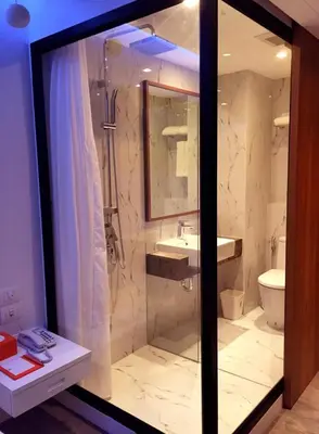 a bathroom with a shower and a sink and a toilet at S Box Sukhumvit Hotel in Bangkok