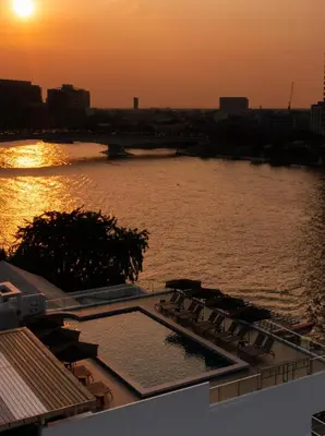 a pool on the roof of a building with a river at The StandardX, Bangkok Phra Arthit in Bangkok