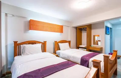 a bedroom with two beds and a mirror at XX GO INN Khaosan Road - Grand Palace in Bangkok