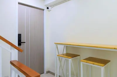 a kitchen with a counter and stools next to a door at Reezq Hostel in Ban Khlong Bang Sai