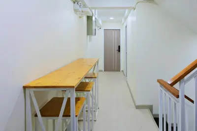 a hallway with a wooden table in a room at Reezq Hostel in Ban Khlong Bang Sai