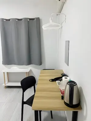 a wooden table with a tea kettle and a chair at GO INN Siriraj - โกอินน์ ศิริราช Pro in Bangkok Noi