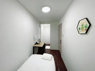 a small room with a bed and a desk at GO INN Siriraj - โกอินน์ ศิริราช Pro in Bangkok Noi