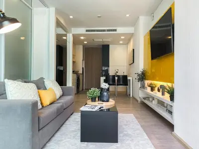 a living room with a couch and a table at Deluxe Suite 1BR Ultra Fast WiFi BTS Thong Lor in Bangkok