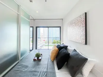 a living room with a couch and a large window at Deluxe Suite 1BR Ultra Fast WiFi BTS Thong Lor in Bangkok