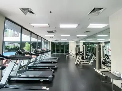 a gym with a row of treadmills and machines at Deluxe Suite 1BR Ultra Fast WiFi BTS Thong Lor in Bangkok