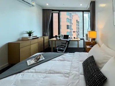 a bedroom with a bed and a desk with a computer at Expansive Luxury 2BR - Ultra Fast Wifi - Phrom Phong in Bangkok