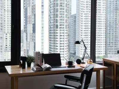 a desk with a laptop computer on it in front of a window at Expansive Luxury 2BR - Ultra Fast Wifi - Phrom Phong in Bangkok