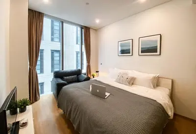a bedroom with a bed with a laptop on it at Transquil Residents 65 SQM - Ultra Fast Wifi - Silom in Bangkok