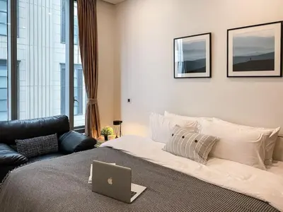 a bedroom with a bed with a laptop on it at Transquil Residents 65 SQM - Ultra Fast Wifi - Silom in Bangkok