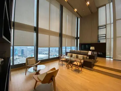 a living room with a couch and tables and chairs at Stylish Riverview 1BR - Ultra Fast WiFi - Phrom Phong in Bangkok
