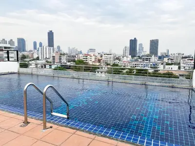 a swimming pool on top of a building with a city skyline at Tropical Haven 1BR - Ultra Fast WiFi - Thong Lo in Bangkok