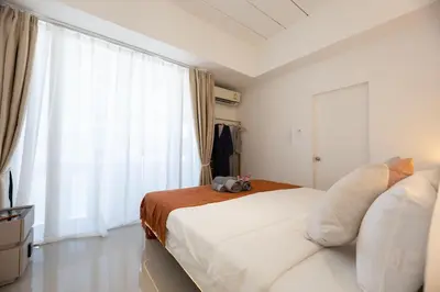 a bedroom with a large bed and a large window at Ratchada Retreat Boutique Suites in Bangkok