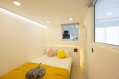 a small bedroom with a bed and a window at Ratchada Retreat Boutique Suites in Bangkok