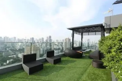 a rooftop garden with benches and a view of a city at Stylish Modern 1BR - BTS Phrom Phong - Ultra Fast WiFi in Bangkok