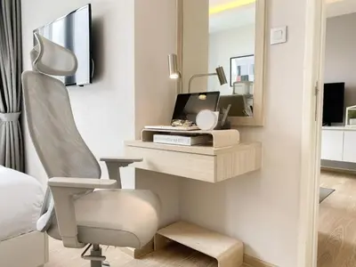 a bedroom with a desk and a chair and a mirror at Stylish Modern 1BR - BTS Phrom Phong - Ultra Fast WiFi in Bangkok