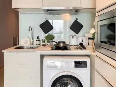a kitchen with a washing machine and a sink at Stylish Modern 1BR - BTS Phrom Phong - Ultra Fast WiFi in Bangkok