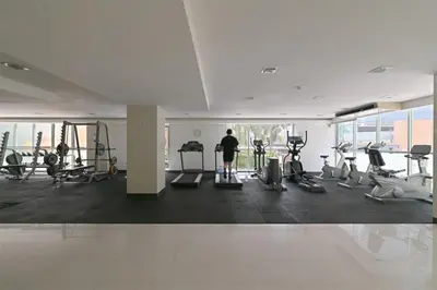 a person in a gym with weights and exercise bikes at Exclusive Modern Apt - Ultra Fast WiFi - Thong Lo in Bangkok