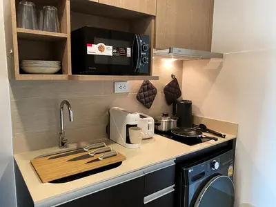 a small kitchen with a stove and a microwave at Luxury Skyview 1BR - Ultra Fast WiFi - Chit Lom in Bangkok