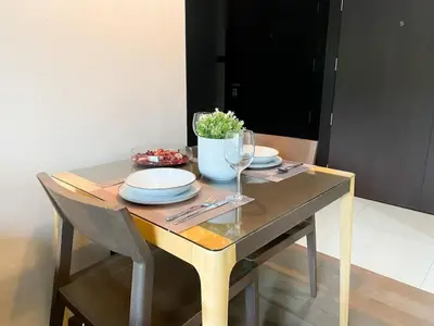 a table with plates and wine glasses on it at Tropical Paradise 1BR - Ultra Fast Wifi - Thong Lo in Bangkok