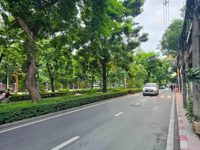 a car driving down a street with trees at Twenty-one BKK House in Bang Kapi