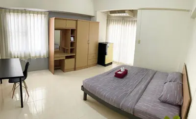 a bedroom with a bed with a red bowl on it at Grand Residence in Bangkok