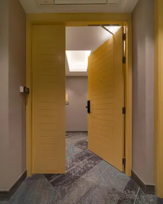 an open yellow door in a room with a hallway at T2 The Portal Sukhumvit in Bangkok